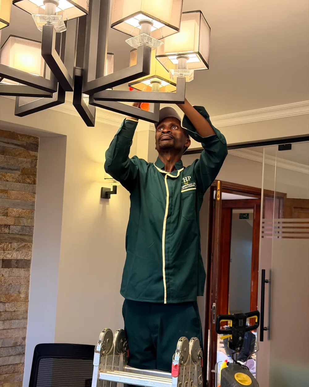 A Happy Place cleaner carefully cleaning a chandelier